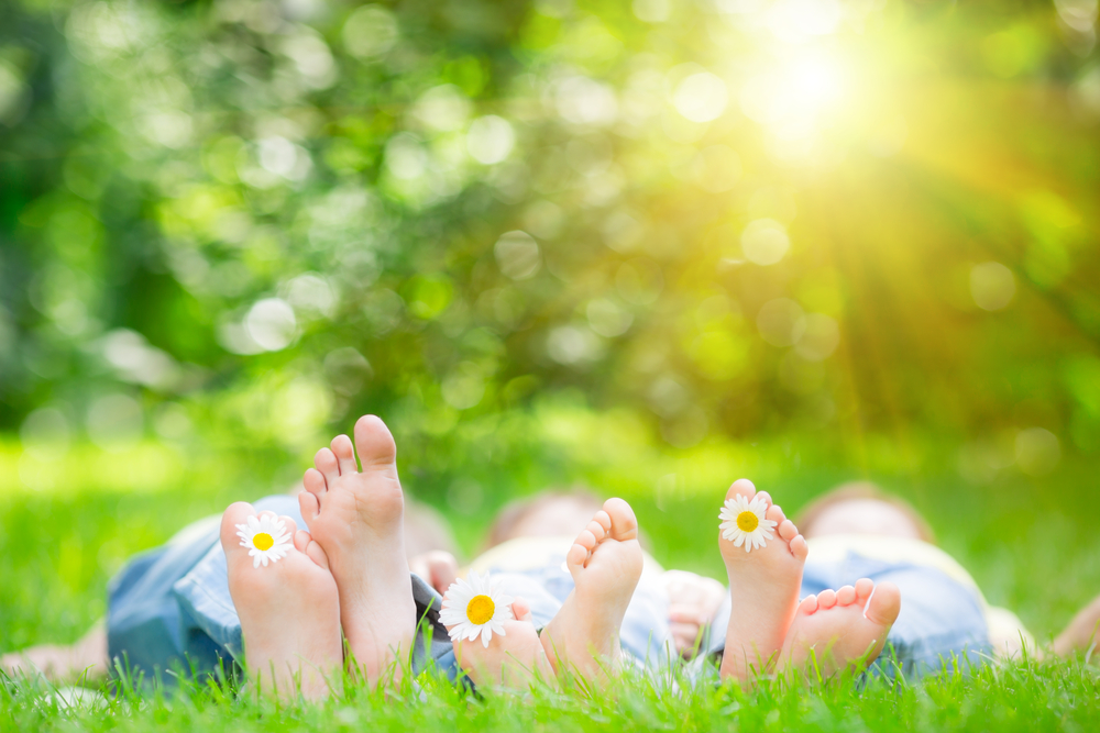 Family,Lying,On,Grass,Outdoors,In,Spring,Park