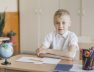 boy-sitting-with-hands-table-classroom